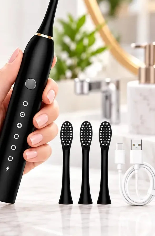 Mano sosteniendo el cepillo NÁCAR negro junto a los cabezales de repuesto y el cable USB